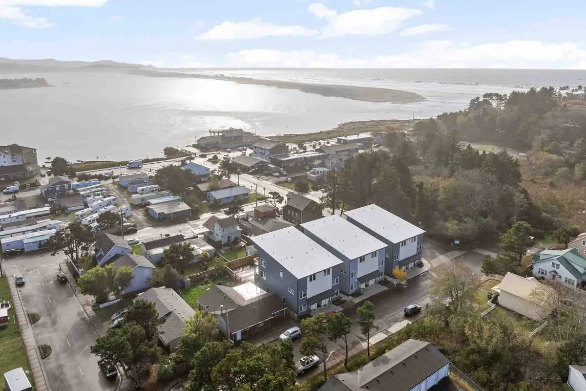 An inviting waterfront view framed by greenery and residential buildings, with people walking along the path. The scene radiates tranquility and social activity, hinting at the pedestrian-friendly environment and vibrant local life.